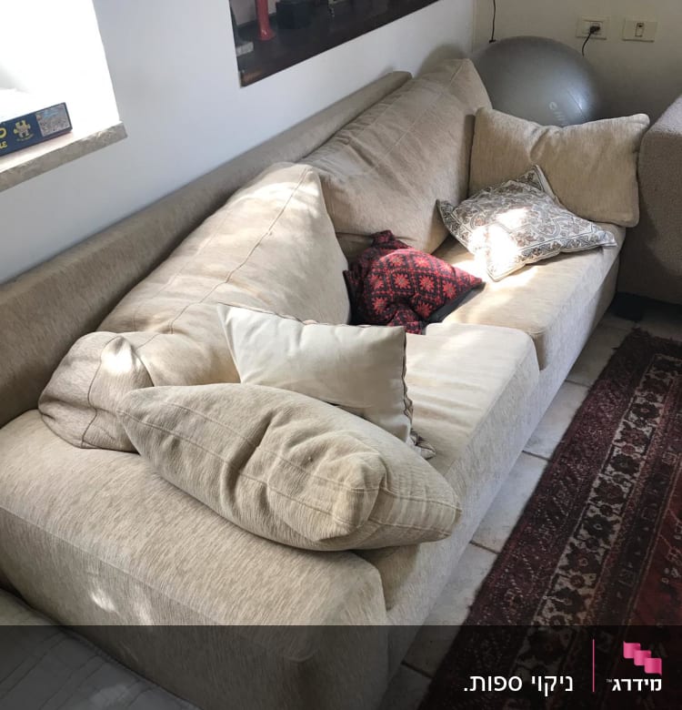 ספה עם כריות שונות על שטיח